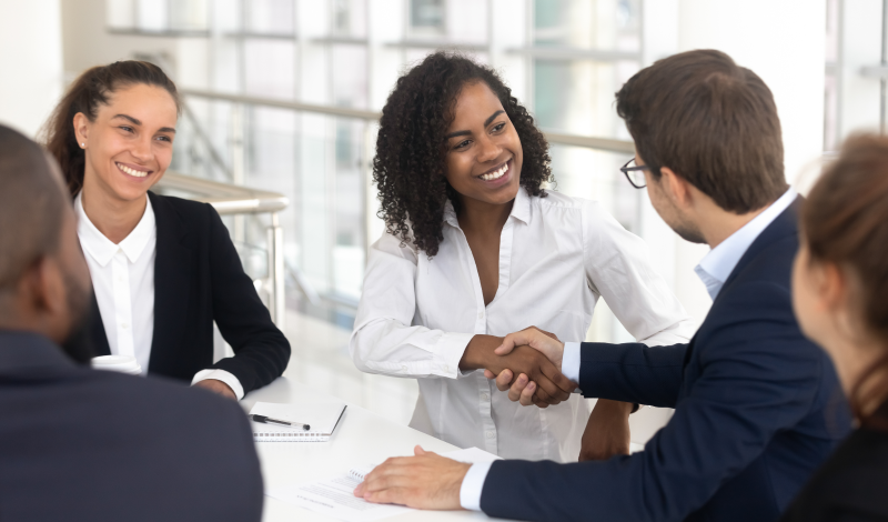 Woman shaking hands with coworker in business meeting